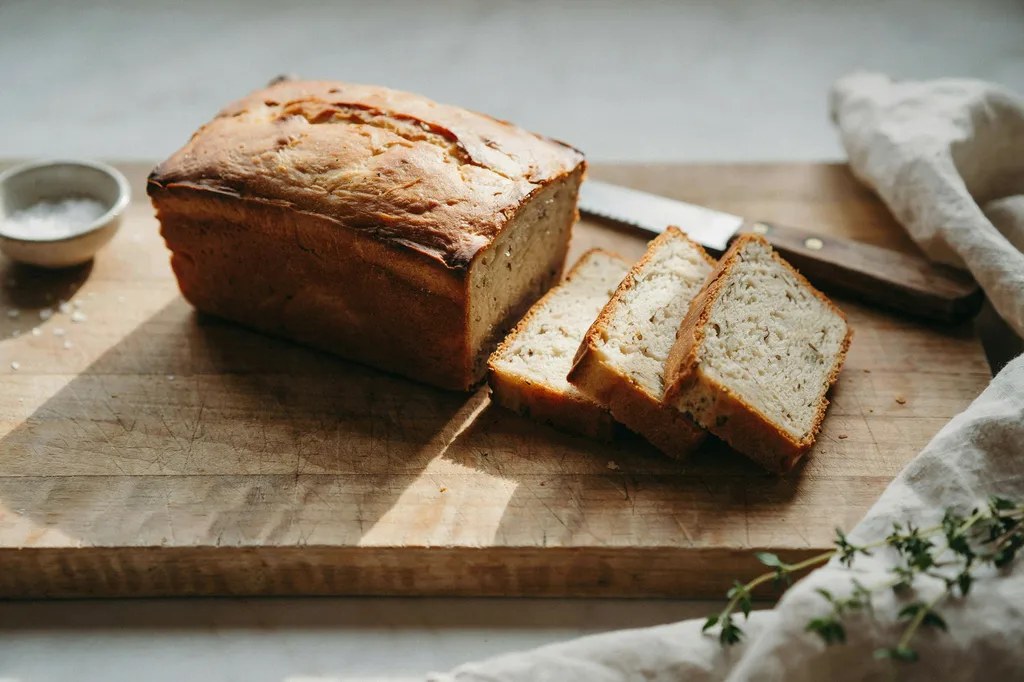 A square-sided pullman loaf with a flat top, precise square slices showing a fine even whole grain crumb.